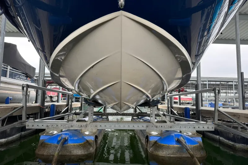 Slide: The Image of 2008 Sea Ray 240 Sundeck boat on lift, showcasing hull design in marina setting. - 2
