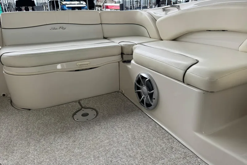 Slide: The Image of 2008 Sea Ray 240 Sundeck interior with beige seating and speaker detail. - 21
