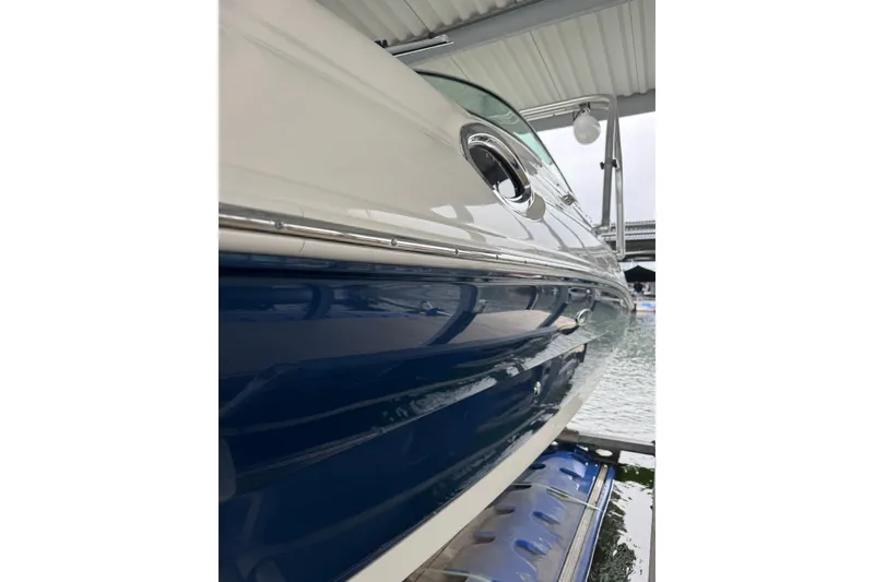 Slide: The Image of 2008 Sea Ray 240 Sundeck boat docked, showcasing sleek blue and white hull design. - 5