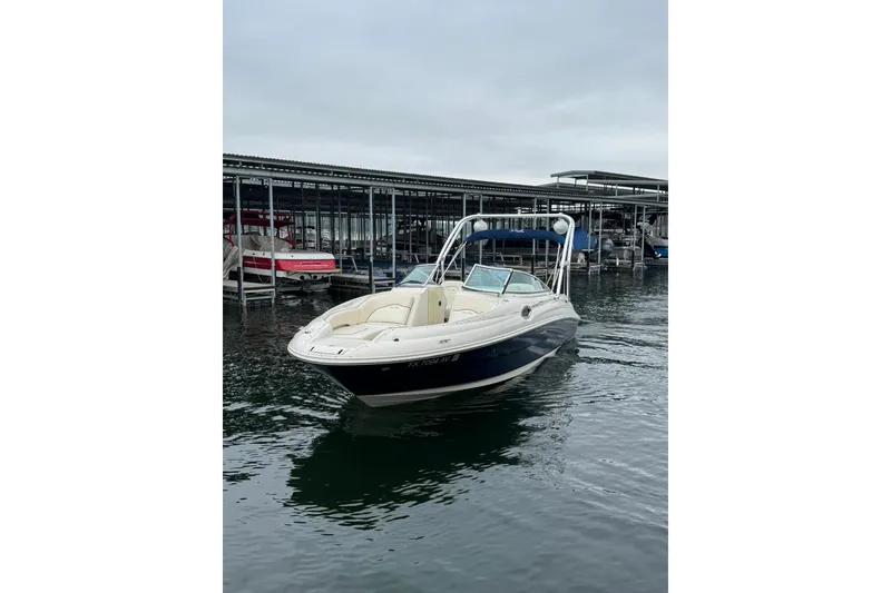 Slide: The Image of 2008 Sea Ray 240 Sundeck boat docked on calm water under cloudy skies. - 9