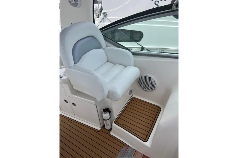 Slide: The Image of Captain's seat on 2003 Sea Ray 340 Sundancer, featuring white upholstery and teak flooring. - 10