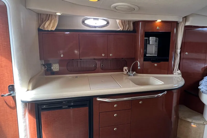 Slide: The Image of Interior of 2003 Sea Ray 340 Sundancer yacht with kitchenette and wooden cabinetry. - 11