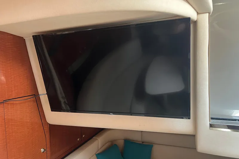 Slide: The Image of Flat-screen TV inside 2003 Sea Ray 340 Sundancer yacht cabin, with wooden cabinetry and cushions. - 13