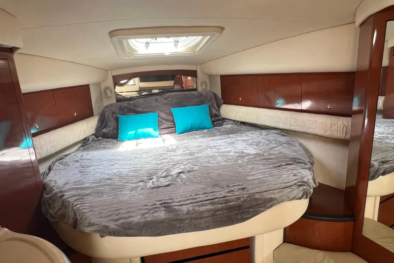 Slide: The Image of Luxurious cabin interior of 2003 Sea Ray 340 Sundancer with plush bedding and teal pillows. - 14