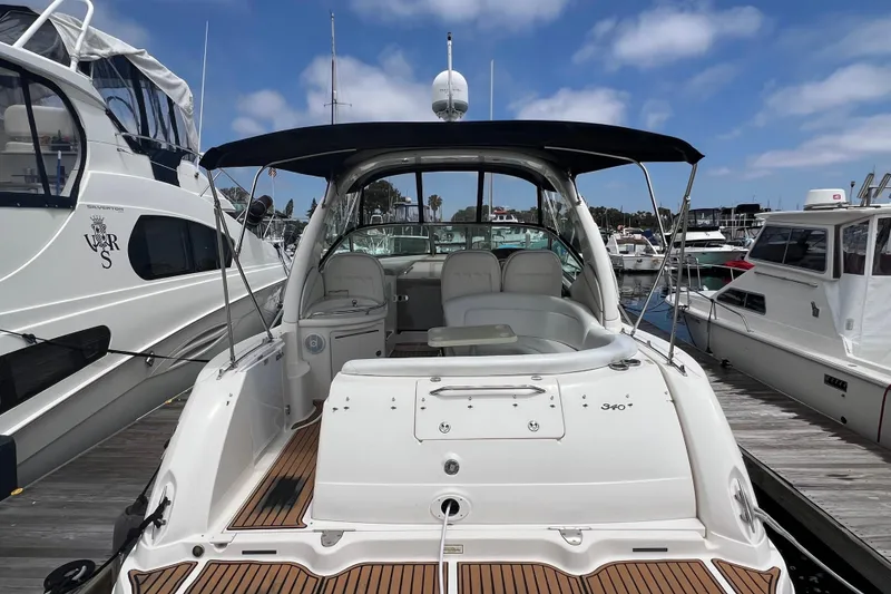 Slide: The Image of 2003 Sea Ray 340 Sundancer yacht docked at marina under clear blue sky. - 3