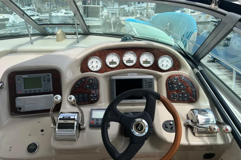 Slide: The Image of 2003 Sea Ray 340 Sundancer helm with gauges, steering wheel, and navigation controls. - 7