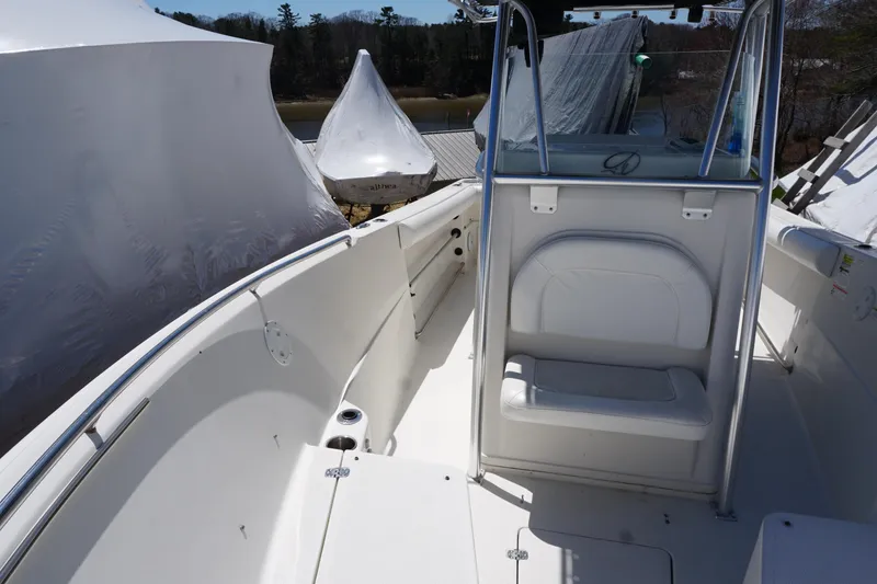 Slide: The Image of 2012 Sailfish 2380 CC boat interior with seating and console, docked outdoors. - 10