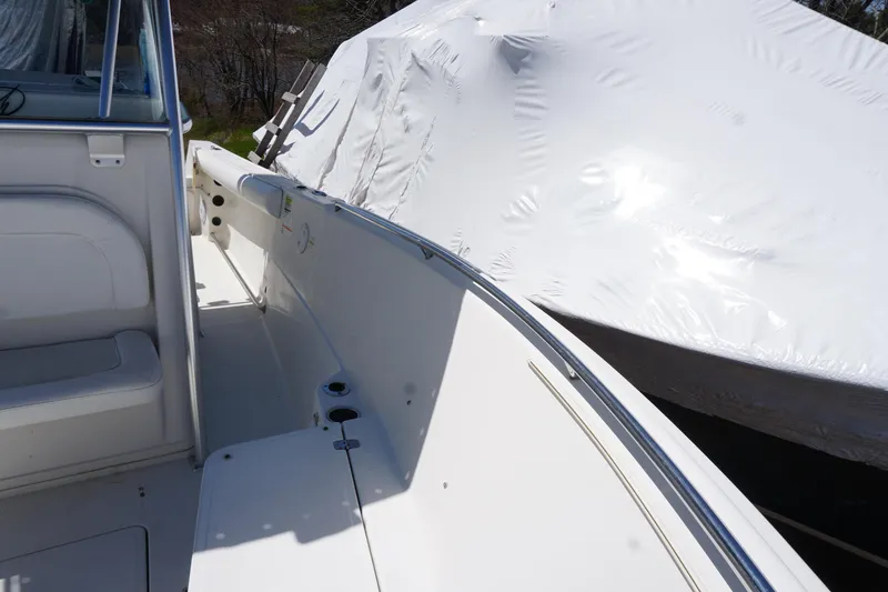 Slide: The Image of 2012 Sailfish 2380 CC boat interior with white seating and covered exterior. - 11