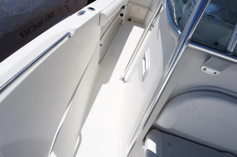 Slide: The Image of Interior view of a 2012 Sailfish 2380 CC boat, featuring sleek white seating and stainless steel railings. - 14