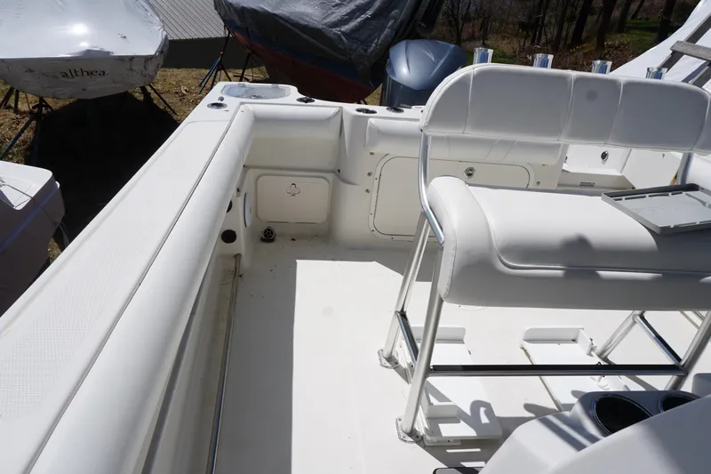 Slide: The Image of 2012 Sailfish 2380 CC boat interior with white seating and storage compartments. - 15