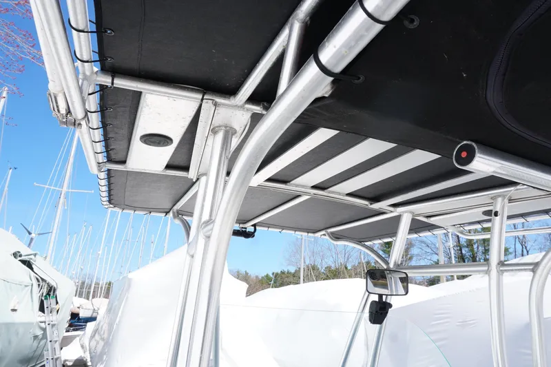Slide: The Image of 2012 Sailfish 2380 CC boat with metal framework and canopy, docked under clear blue sky. - 20