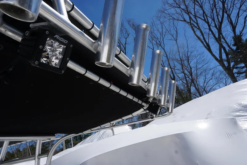 Slide: The Image of 2012 Sailfish 2380 CC boat with rod holders and Rigid LED light, under clear blue sky. - 21