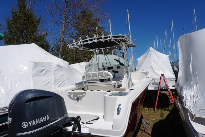 Slide: The Image of 2012 Sailfish 2380 CC boat with Yamaha engine, stored outdoors, surrounded by covered boats. - 28