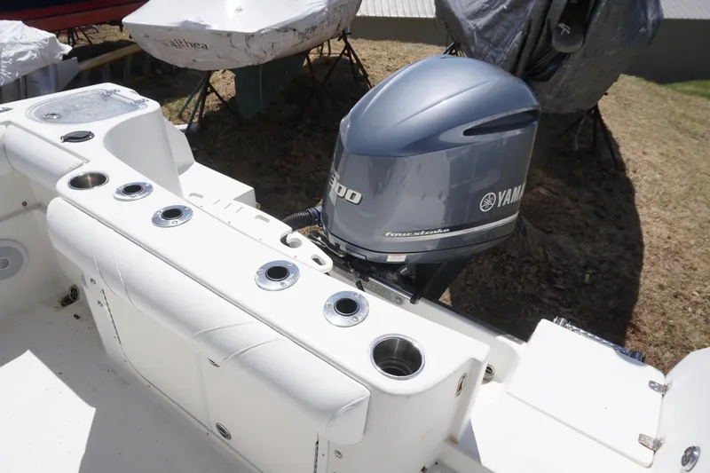 Slide: The Image of 2012 Sailfish 2380 CC boat with Yamaha outboard motor, featuring rod holders and seating. - 7