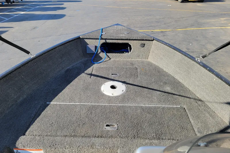 Slide: The Image of 2017 Lowe Fishing Machine 160S boat interior with carpeted deck and storage compartments. - 12
