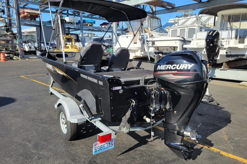 Slide: The Image of 2017 Lowe Fishing Machine 160S with Mercury outboard motor on trailer in marina setting. - 3