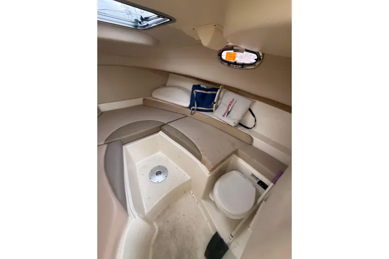 Slide: The Image of Interior cabin of 2012 Boston Whaler 255 Conquest boat, featuring seating and a small toilet. - 24