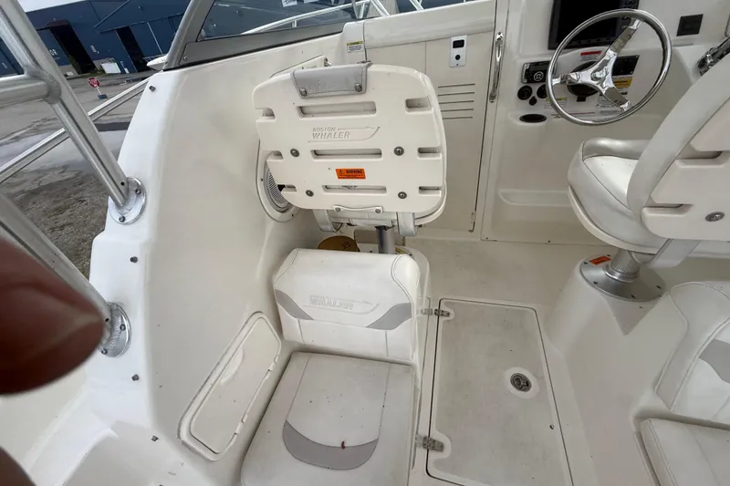Slide: The Image of Interior of a 2012 Boston Whaler 255 Conquest boat, featuring seating and steering wheel. - 32
