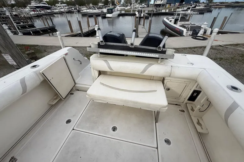 Slide: The Image of 2012 Boston Whaler 255 Conquest boat interior at marina, featuring seating and storage compartments. - 34