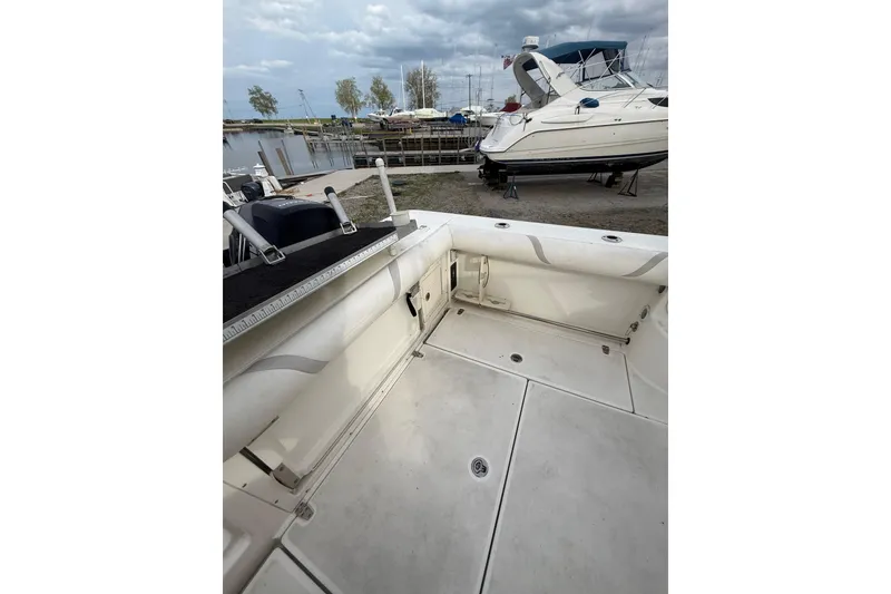 Slide: The Image of 2012 Boston Whaler 255 Conquest boat interior, docked near other vessels under cloudy skies. - 37