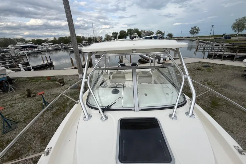 Slide: The Image of 2012 Boston Whaler 255 Conquest boat docked at a marina under cloudy skies. - 7