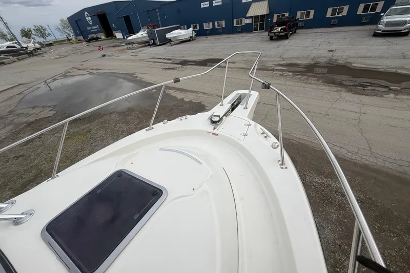 Slide: The Image of 2012 Boston Whaler 255 Conquest boat docked at a marina with blue buildings. - 8