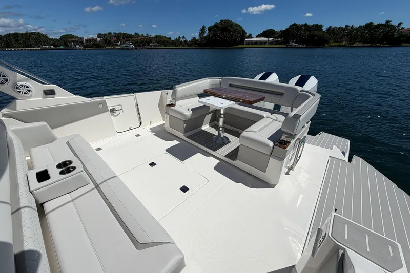 Slide: The Image of 2024 Tiara Yachts 43 LS luxury deck with seating and table on calm water. - 13