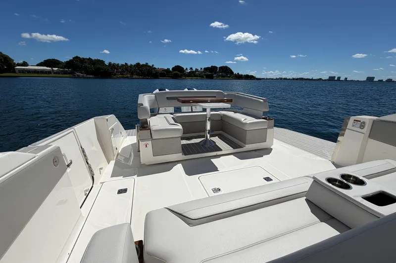 Slide: The Image of 2024 Tiara Yachts 43 LS luxury deck with seating, overlooking serene water and clear sky. - 18