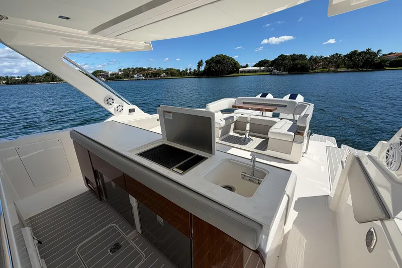 Slide: The Image of 2024 Tiara Yachts 43 LS luxury yacht interior with seating and kitchenette, overlooking serene water. - 20