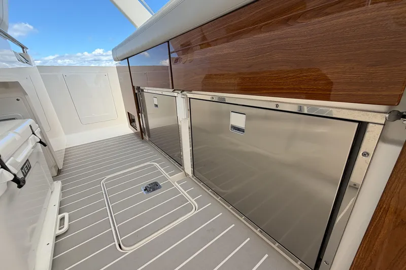 Slide: The Image of 2024 Tiara Yachts 43 LS interior with sleek wood paneling and stainless steel features. - 21