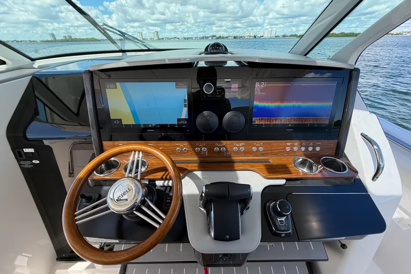 Slide: The Image of 2024 Tiara Yachts 43 LS helm with advanced navigation displays and wooden steering wheel. - 28