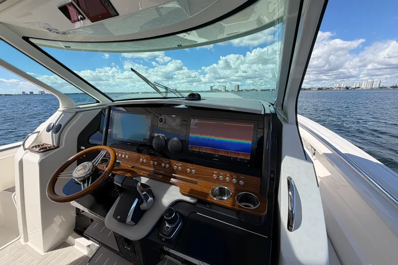 Slide: The Image of 2024 Tiara Yachts 43 LS helm with advanced navigation system, steering wheel, and ocean view. - 29