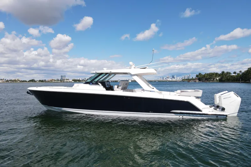 Slide: The Image of 2024 Tiara Yachts 43 LS cruising on a sunny day with city skyline in background. - 3