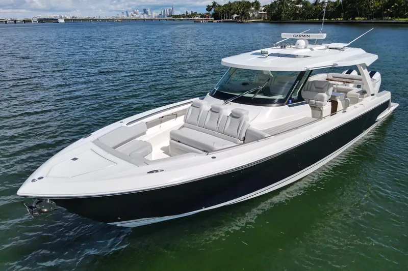 Slide: The Image of 2024 Tiara Yachts 43 LS luxury boat on calm water, city skyline in background. - 4