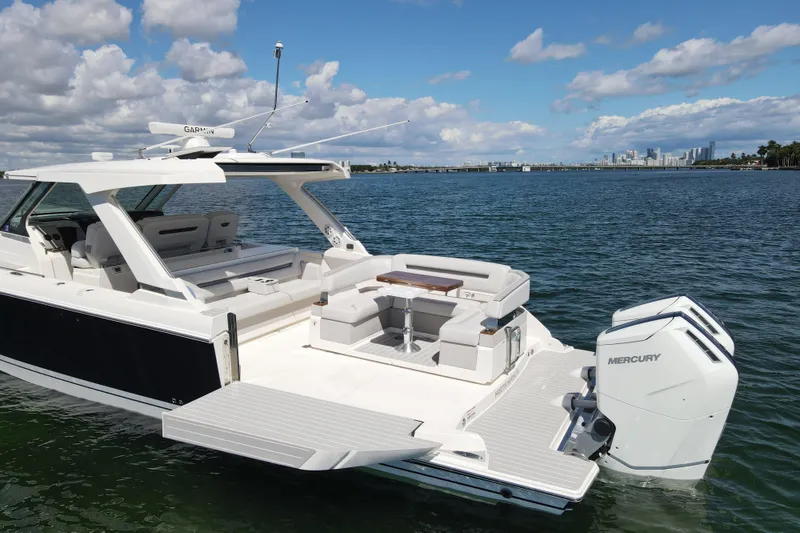 Slide: The Image of 2024 Tiara Yachts 43 LS luxury boat on water with city skyline in background. - 8
