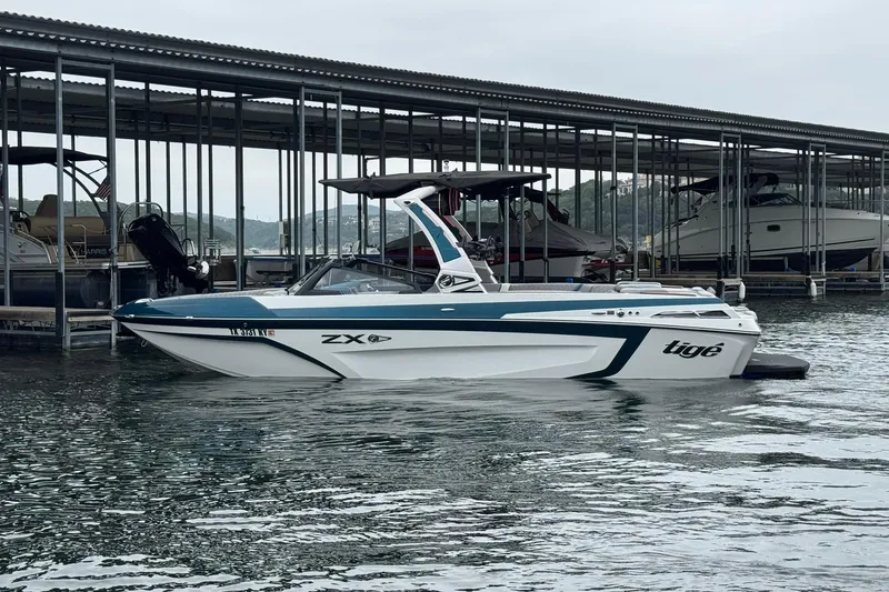 The Image of 2023 Tigé 25ZX boat docked in a marina, showcasing sleek design and modern features. - 0