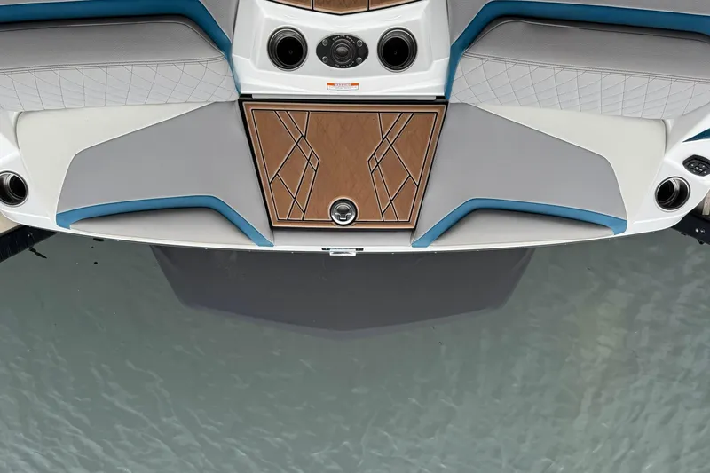 Slide: The Image of 2023 Tigé 25ZX boat interior with stylish seating and wood accents on water. - 12
