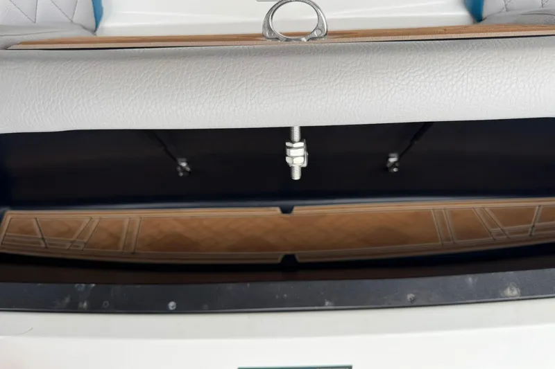 Slide: The Image of 2023 Tigé 25ZX boat interior storage compartment with cushioned seating and wooden flooring. - 14