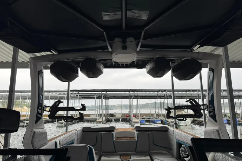 Slide: The Image of 2023 Tigé 25ZX boat interior with speakers and seating at a marina. - 35