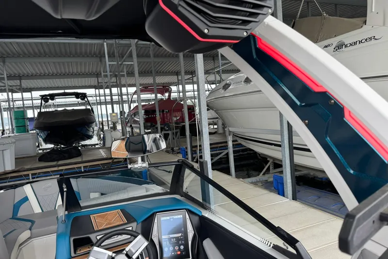 Slide: The Image of 2023 Tigé 25ZX boat interior with advanced dashboard, docked in a marina. - 36