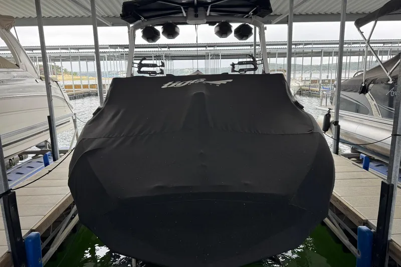 Slide: The Image of 2023 Tigé 25ZX boat covered and docked in a marina. - 38