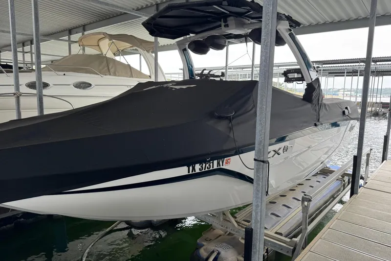 Slide: The Image of 2023 Tigé 25ZX boat covered and docked in a marina. - 8
