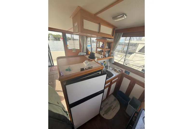 Slide: The Image of Interior of a 1990 Cooper Prowler boat with kitchen area and view of marina. - 11