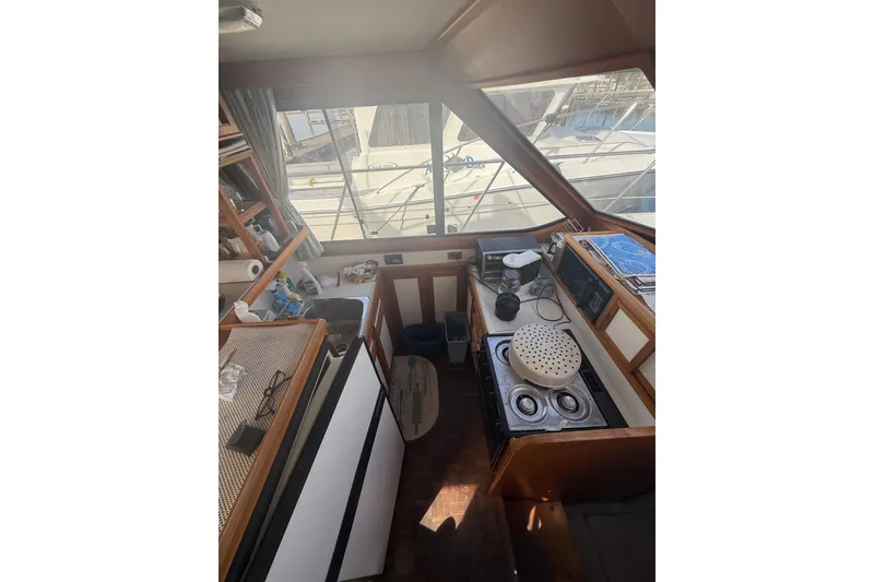 Slide: The Image of Interior of 1990 Cooper Prowler boat kitchen with stove, sink, and window view. - 12