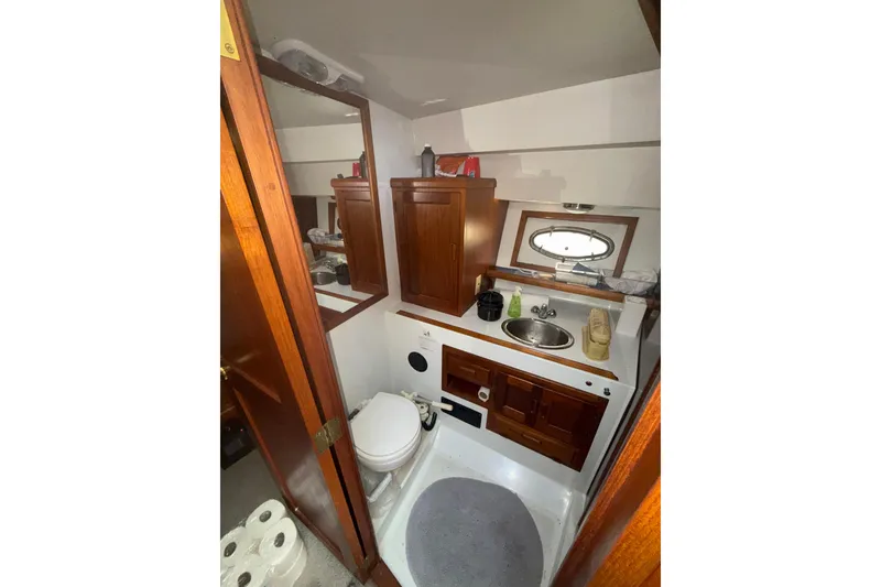 Slide: The Image of 1990 Cooper Prowler boat bathroom with wooden cabinets and compact sink. - 13