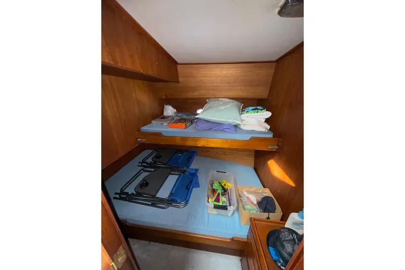 Slide: The Image of Interior of a 1990 Cooper Prowler boat with bunk beds and storage items. - 14