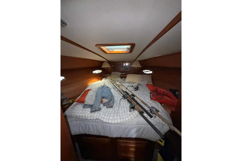 Slide: The Image of Cozy cabin interior of 1990 Cooper Prowler with fishing rods and casual clothing on bed. - 15
