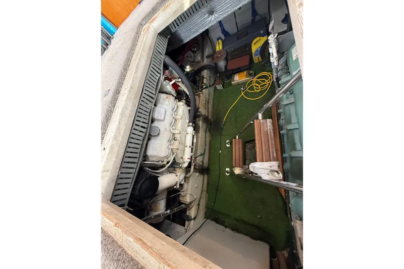 Slide: The Image of Engine room of a 1990 Cooper Prowler boat, featuring mechanical components and storage items. - 17