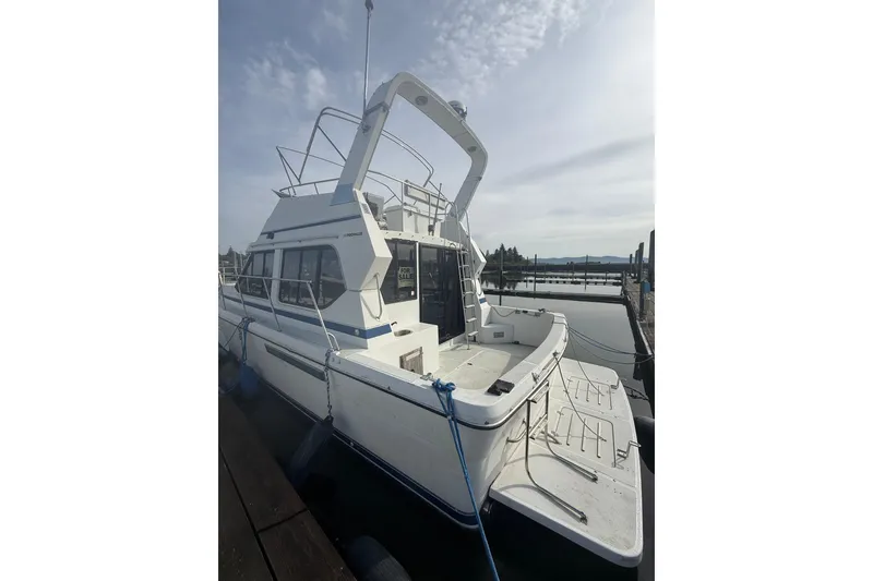 Slide: The Image of 1990 Cooper Prowler boat docked, white exterior, for sale sign visible. - 2