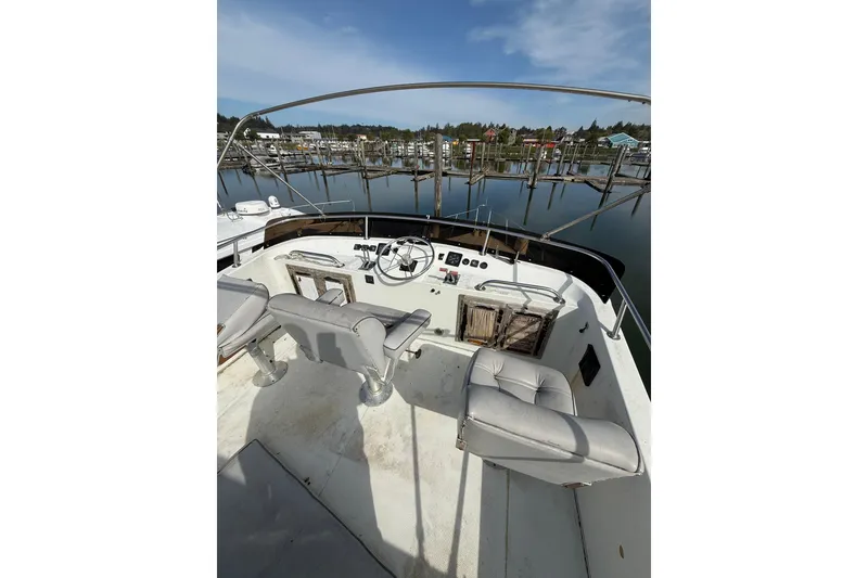 Slide: The Image of 1990 Cooper Prowler boat cockpit with steering wheel and seats, docked at marina. - 20